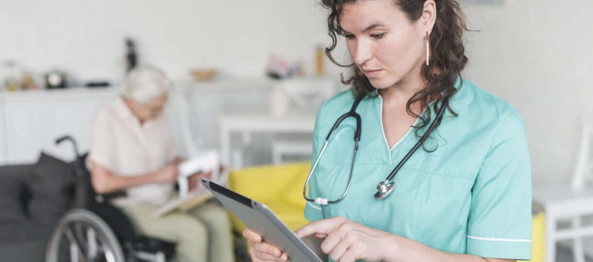 female-nurse-using-digital-tablet-standing-front-senior-woman-sitting-wheelchair-1536x1025